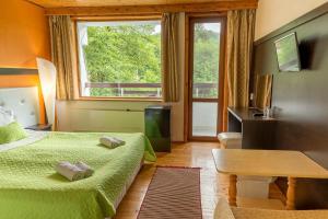 卡洛费尔天堂酒店的一间卧室设有两张床、一张桌子和一个窗口