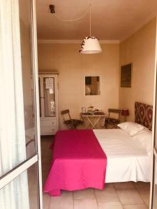 圣乔瓦尼镇澳麦霍姆住宿加早餐旅馆的一间卧室配有一张带粉色毯子的大床