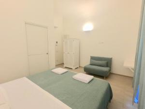 萨沃纳Central Savona B&B的一间卧室配有一张床和一把绿色椅子