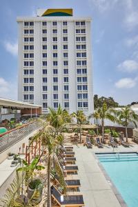 洛杉矶Hotel June West LA, a Member of Design Hotels的一座带游泳池和大型建筑的酒店
