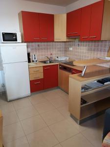 斯普利特梅亚公寓的厨房配有红色橱柜和白色冰箱
