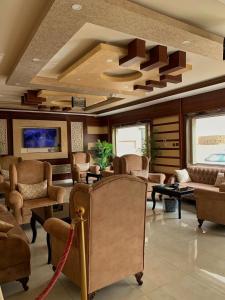 奈季兰Alshahamah Hotel Apartments的客厅配有椅子、沙发和桌子