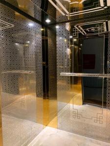 奈季兰Alshahamah Hotel Apartments的一间设有玻璃墙和桌子的房间