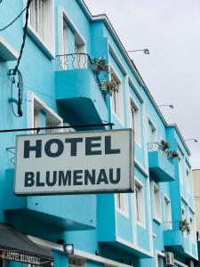 库里提巴Hotel Blumenau Centro的大楼一侧的比利马努旅馆标志