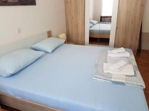 塞尼Apartment Skale的一间卧室配有带毛巾和镜子的床