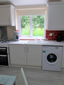 拉斯德拉姆Lettermore 1 Apartment的厨房配有洗衣机和窗户。