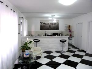 马达莱纳Clelia's Boutique Rooms & Suites的厨房铺有黑白的格子地板。