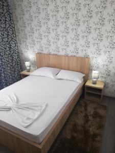 科尔布Vila antonio的一间卧室配有一张带白色床单和壁纸的床