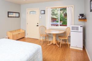 西沃德Steller Inn的一间卧室配有桌子、两把椅子和窗户