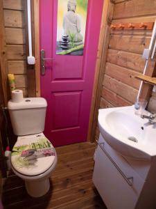 勒穆莱La Roulotte De Tina的一间带卫生间和粉红色门的浴室
