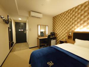 米子市Green Rich Hotel Yonago Ekimae (Artificial hot spring Futamata Yunohana)的配有一张床和一张书桌的酒店客房