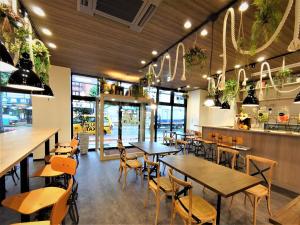 米子市Green Rich Hotel Yonago Ekimae (Artificial hot spring Futamata Yunohana)的餐厅设有木桌、椅子和窗户。