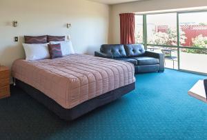 提马鲁ASURE阿什利汽车旅馆的一间卧室配有一张大床和一张沙发