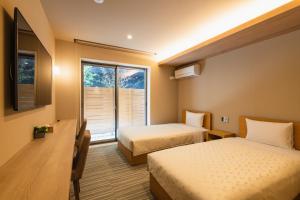 福冈GRAND BASE Fukuoka Tenjin的酒店客房设有两张床和窗户。