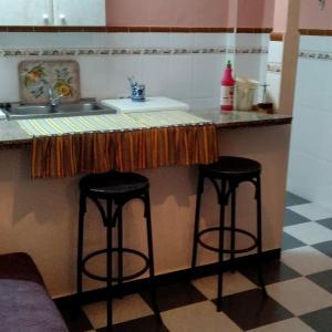 安度亚尔La Isabelita的厨房配有2把吧台凳和水槽