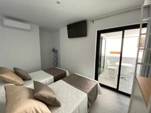 洛斯·亚诺斯·德·阿里丹Flying La Palma - Sostenible的一间卧室设有两张床和滑动玻璃门