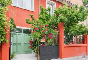 里昂Lyon Urban Cocoon Gîte urbain eco-responsable的一个带红色门的车库,里面装有鲜花