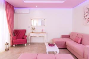 斯卡拉马里昂Dream View的客厅配有粉红色的沙发和2把红色的椅子