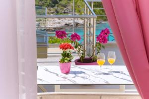斯卡拉马里昂Dream View的阳台上的桌子上放着两杯葡萄酒和鲜花
