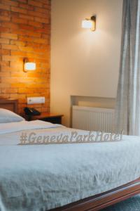 敖德萨日内瓦公园酒店的一间卧室设有一张床和砖墙