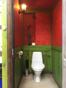 凯卡瓦自治市桑给巴尔露营旅馆的浴室设有卫生间,拥有红色和绿色的墙壁