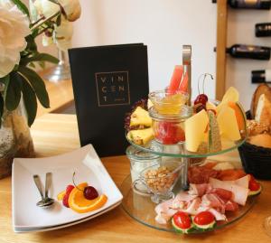 雷根斯堡勒奥斯泰罗老城酒店的桌上的盘子,包括奶酪和水果