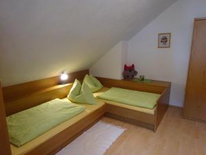拉肯霍夫奥夏泰福民宿的一间卧室配有两张带绿色枕头的床