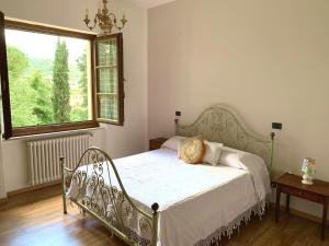 Pieve a MaianoAgriturismo La Collina Toscana的卧室内的一张床铺,设有大窗户