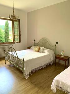 Pieve a MaianoAgriturismo La Collina Toscana的一间卧室配有一张床、一张桌子和一个窗户。
