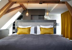 苏黎世泽费尔德速乐酒店的一间卧室配有一张带黄色枕头的大床