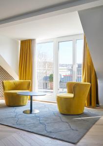 苏黎世泽费尔德速乐酒店的客厅配有2把黄色椅子和桌子