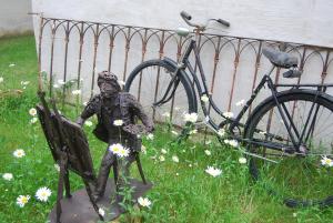 巴特拉德克斯堡City Appartement的坐在自行车旁长凳上的人的雕像
