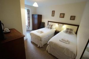 贝图瑟科伊德教堂山之家旅馆的酒店客房,配有两张带白色床单的床