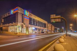 利雅德Ewaa Express Hotel - Khurais的夜间有交通灯和建筑物的城市街道