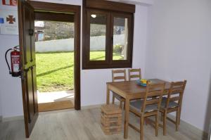 Albergue Cascoxu的一间带桌椅和窗户的用餐室