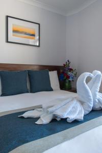 布莱顿霍夫新斯坦住宿加早餐酒店的蓝色地毯上床和2条天鹅毛巾