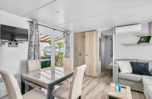 瓦尔拉普拉日Particulier loue ce mobil-home 3 chambres, tout confort的客厅配有桌子和沙发