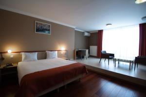 扎芬特姆陶尔米纳布鲁塞尔机场酒店的酒店客房设有一张大床和一张书桌。