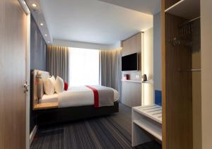 爱丁堡快捷假日爱丁堡市中心酒店的一间卧室设有一张床和一个大窗户
