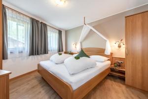 瓦尔奥纳的圣乔凡尼AlpenChalet Niederkofler的卧室配有白色大床和白色枕头