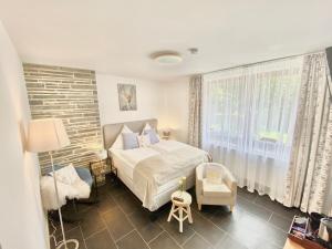 锡默拉特JUULS - Natur Hotel Garni的卧室配有床、椅子和窗户。