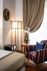 佛罗伦萨AQA Palace的一间卧室配有一张床、一把椅子和一盏灯