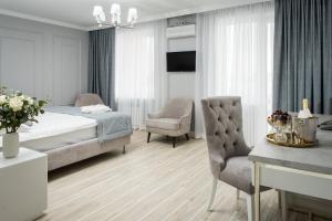 乌拉尔斯克Rakhat Hotel的一间卧室配有一张床、一把椅子和一张桌子
