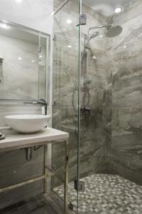 乌拉尔斯克Rakhat Hotel的一间带水槽和玻璃淋浴的浴室
