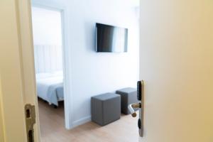 埃斯卡斯特利HOTEL SON VILAR的一间设有一张床的房间和一扇带电视的门