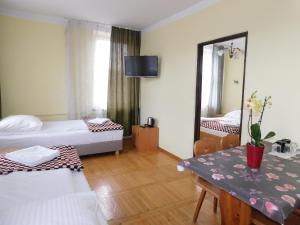 克拉科夫珀考叶高斯娜可若娜酒店的酒店客房设有两张床、一张桌子和镜子