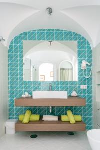 卡普里阿尔达罗奇酒店的蓝色瓷砖浴室设有水槽和镜子