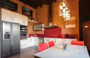 托罗Castillo de Monte la Reina Posada Real & Bodega的厨房配有红色椅子和不锈钢冰箱
