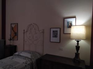 萨尔扎纳Villa Carlotta的一间卧室配有一张带灯和墙上照片的床。