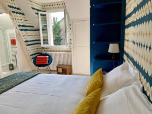 维希La Villégiature的一间卧室配有一张蓝色床头板的床